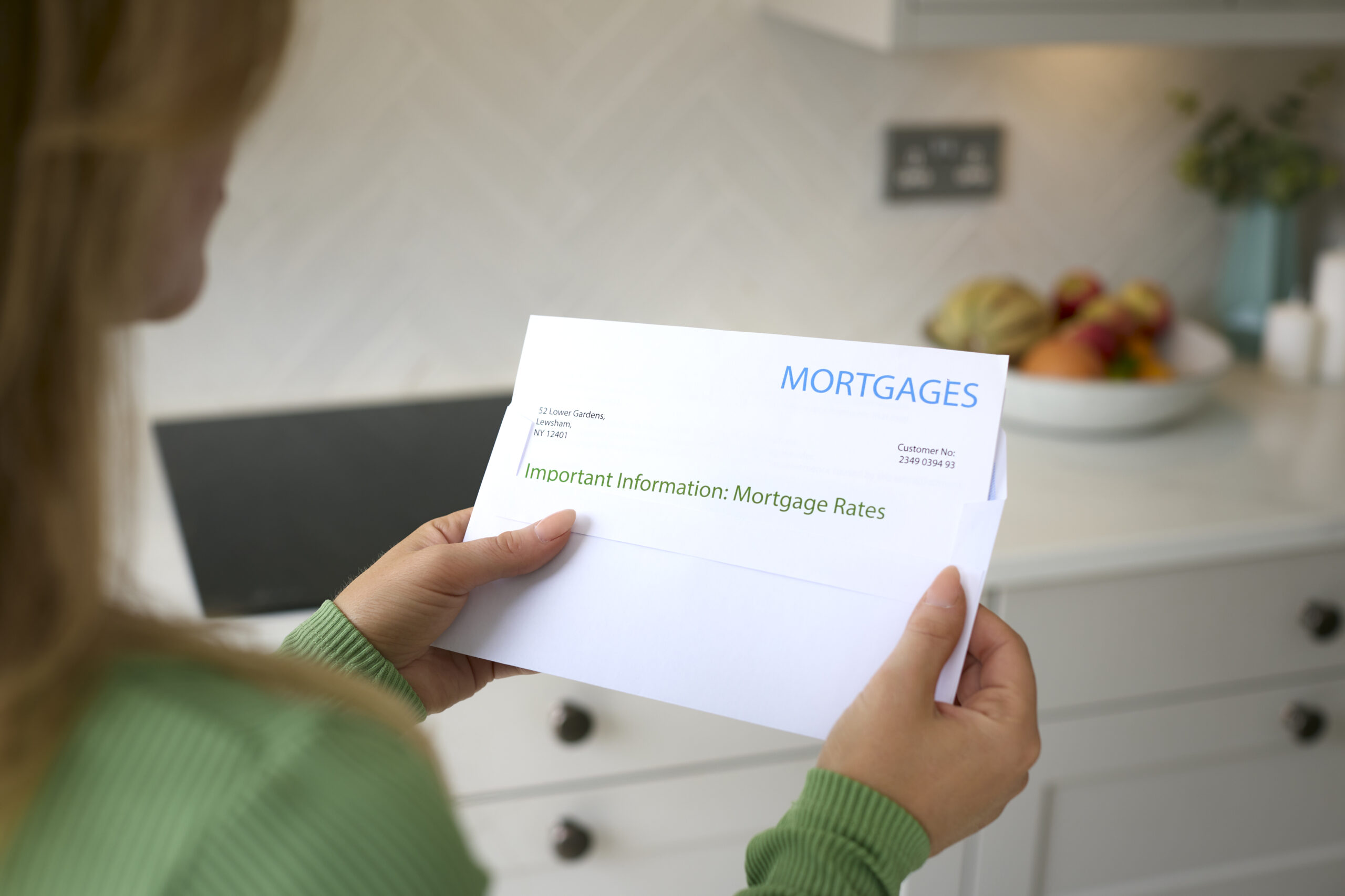 Homeowner reviewing a mortgage rates letter in her kitchen