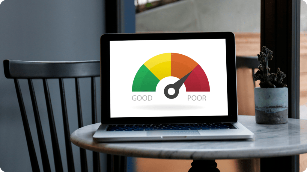 Laptop showing a credit score gauge from good to poor for mortgage loan qualification