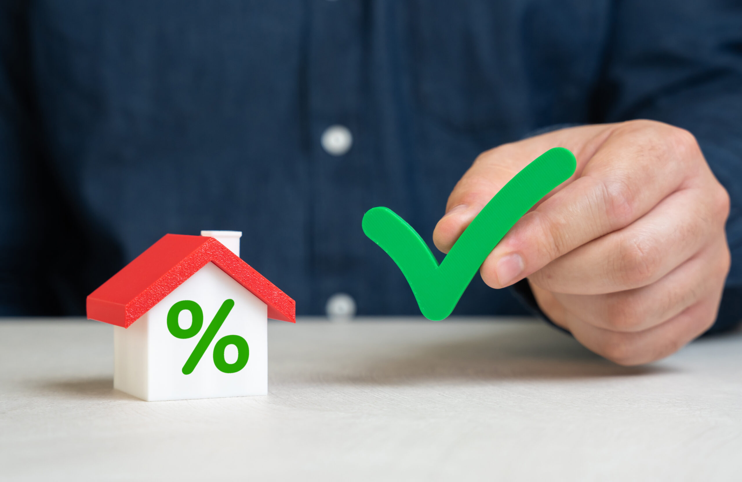 House icon with percent sign and green checkmark for mortgage approval